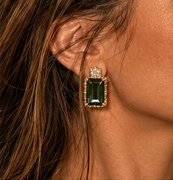 Detalhe de brinco dourado com pedra verde na identidade visual Áurea